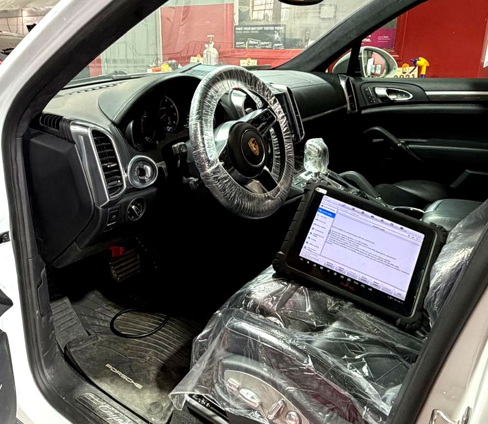 Diagnostic scan tool on the seat of a Porsche Cayenne Turbo