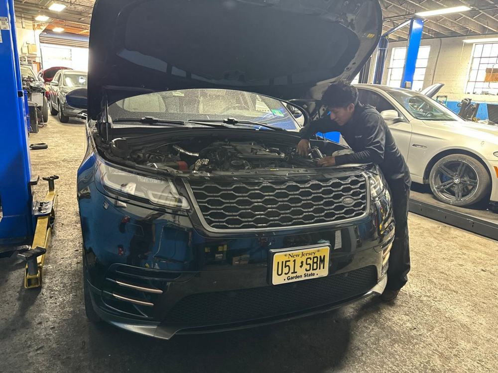 Technician working under the hood of a Range Rover
